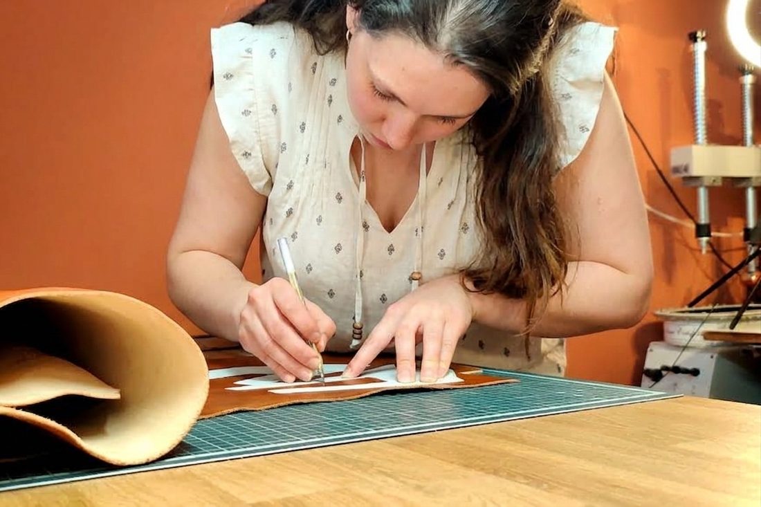Delphine Rouchon trace un patron sur une peau de cuir à l'atelier